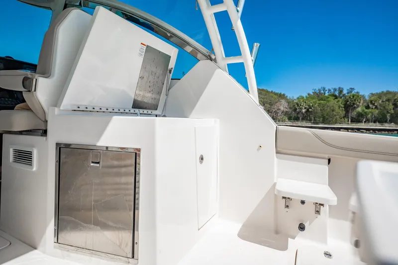 Waikiki Yacht Photos Pics 2017 Pursuit DC 325 Dual Console boat interior with storage and seating, under clear blue sky.