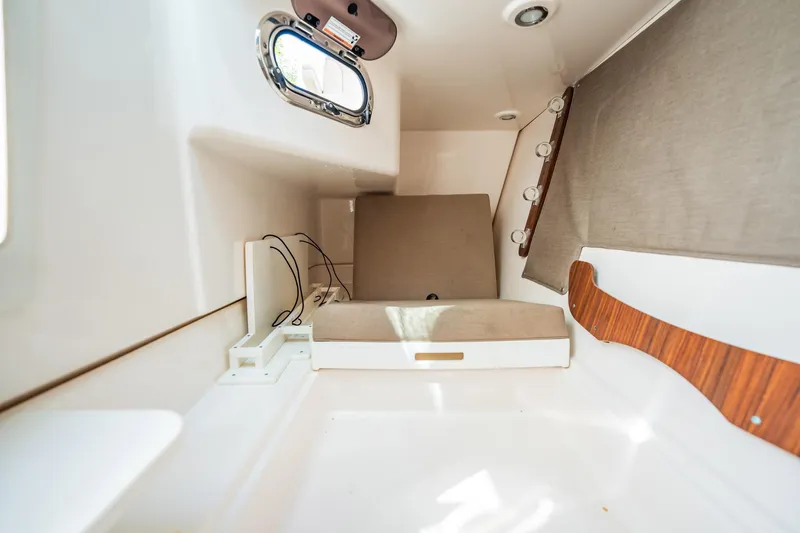 Waikiki Yacht Photos Pics 2017 Pursuit DC 325 Dual Console cabin interior with seating and porthole window.