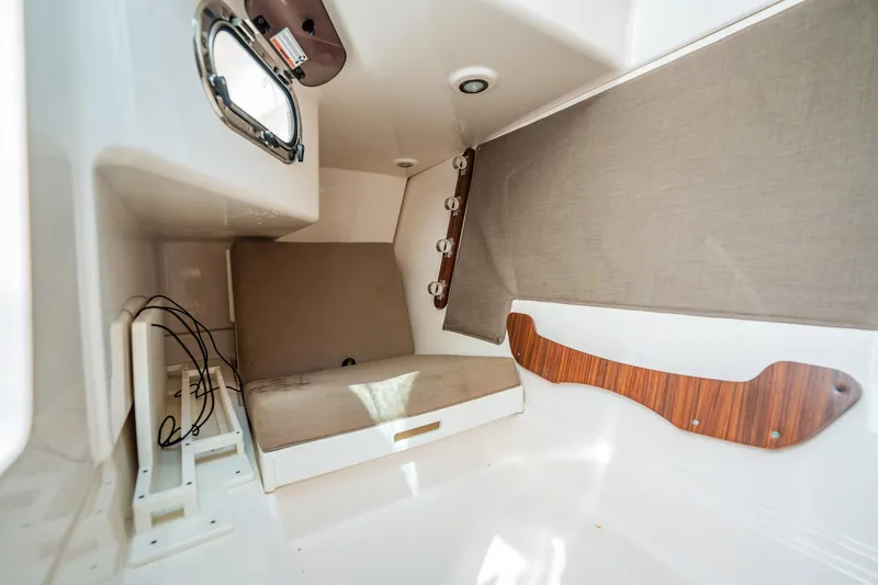 Waikiki Yacht Photos Pics 2017 Pursuit DC 325 Dual Console cabin interior with seating and porthole.