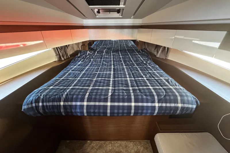  Yacht Photos Pics 2019 Jeanneau NC33 cabin with plaid bedding and modern interior design.