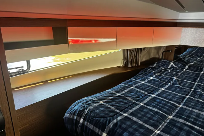  Yacht Photos Pics Interior cabin of 2019 Jeanneau NC33 yacht with bed and storage cabinets.