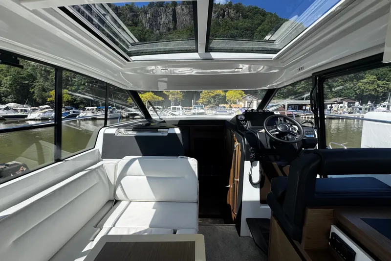  Yacht Photos Pics Interior of 2019 Jeanneau NC33 yacht with panoramic windows and modern helm.