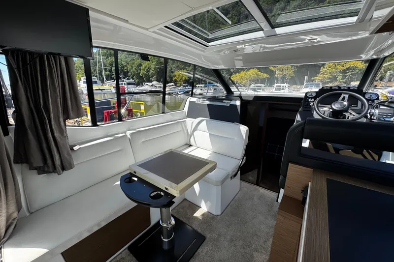  Yacht Photos Pics Interior of 2019 Jeanneau NC33 yacht with modern seating and steering area.