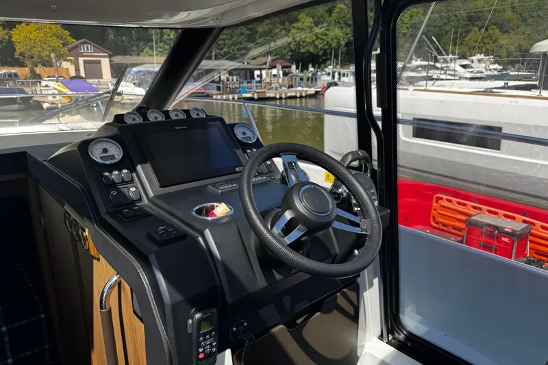  Yacht Photos Pics 2019 Jeanneau NC33 helm with modern controls and marina view.