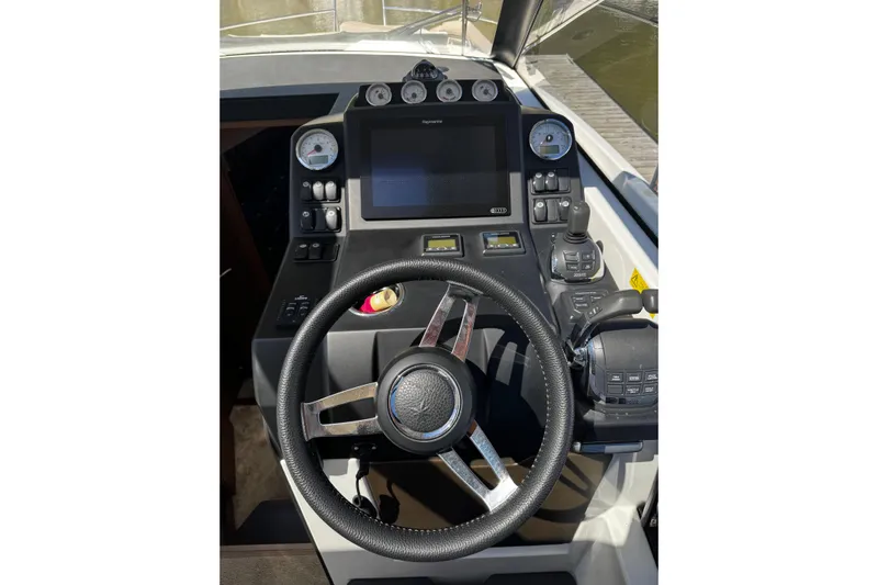  Yacht Photos Pics Cockpit of 2019 Jeanneau NC33 boat with steering wheel and navigation controls.