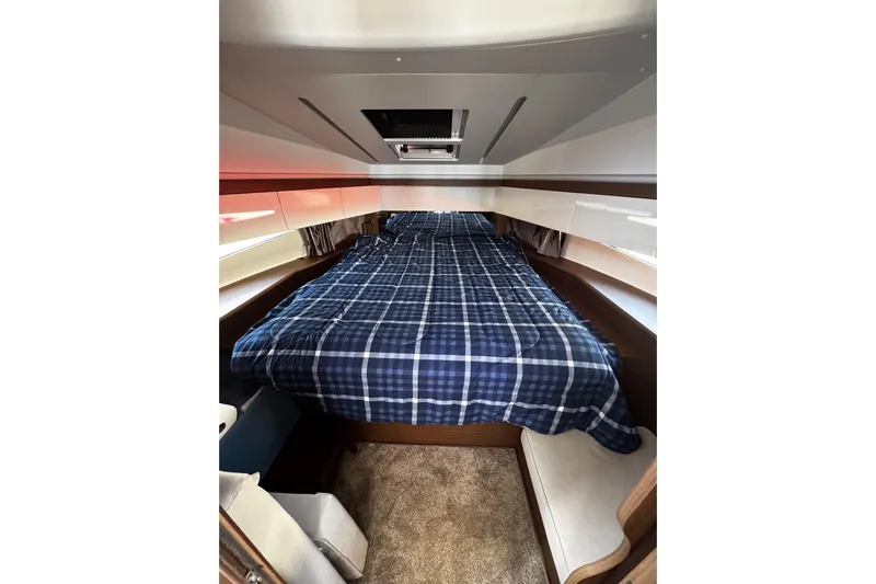  Yacht Photos Pics Cozy cabin interior of 2019 Jeanneau NC33 with plaid bedding and modern design.