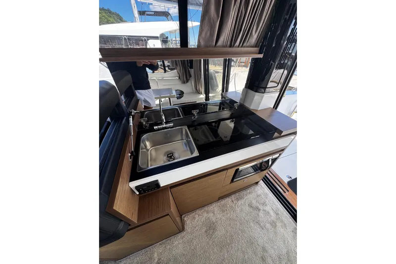  Yacht Photos Pics 2019 Jeanneau NC33 yacht interior kitchen with sink and stove.