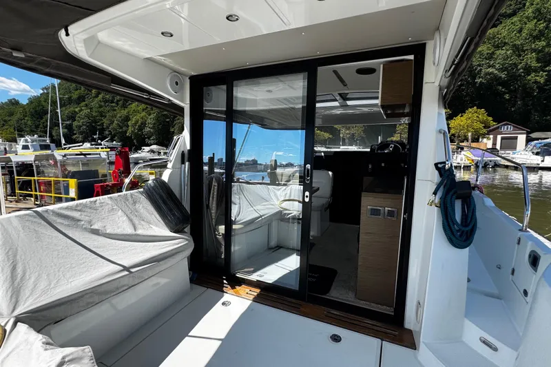  Yacht Photos Pics 2019 Jeanneau NC33 yacht with sliding glass doors, docked at a marina.