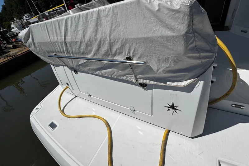 Yacht Photos Pics 2019 Jeanneau NC33 boat stern with cover and yellow hose.