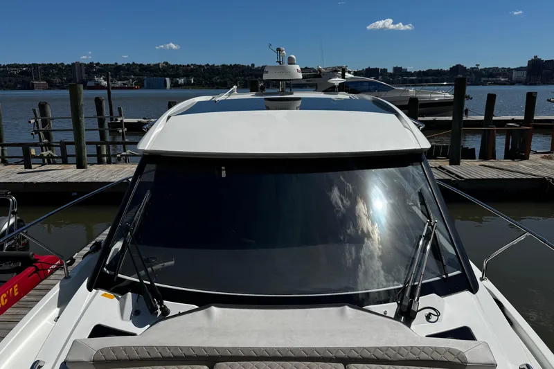  Yacht Photos Pics 2019 Jeanneau NC33 yacht docked at a marina with a scenic waterfront view.