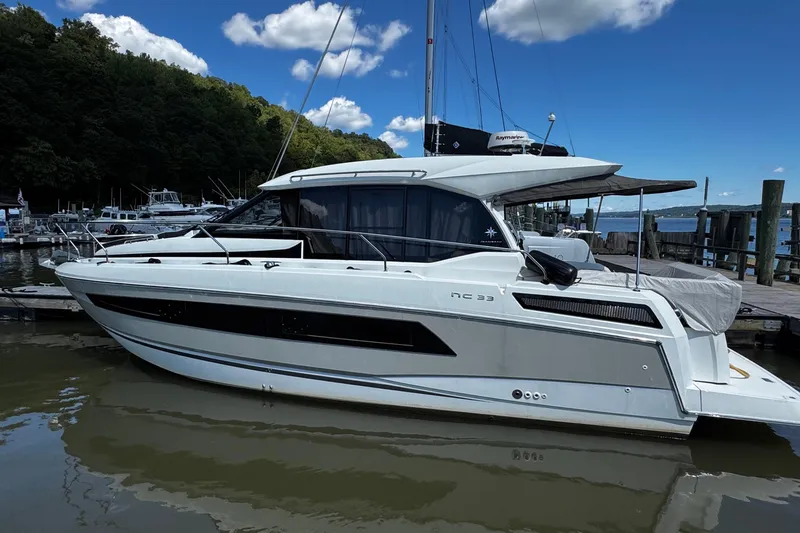  Yacht Photos Pics 2019 Jeanneau NC33 yacht docked at marina under blue sky.