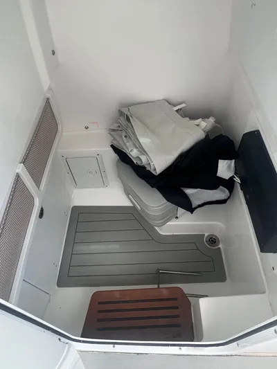  Yacht Photos Pics 2023 Everglades 253 CC boat interior storage area with folded gear and equipment.