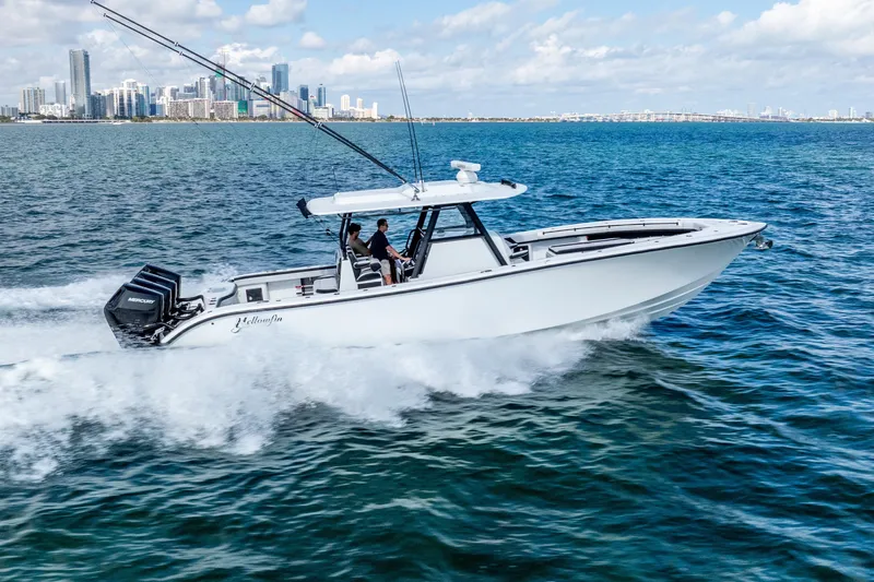  Yacht Photos Pics 2024 Yellowfin 39 Offshore boat cruising on ocean near city skyline.