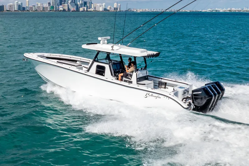  Yacht Photos Pics 2024 Yellowfin 39 Offshore boat cruising on ocean with city skyline in background.