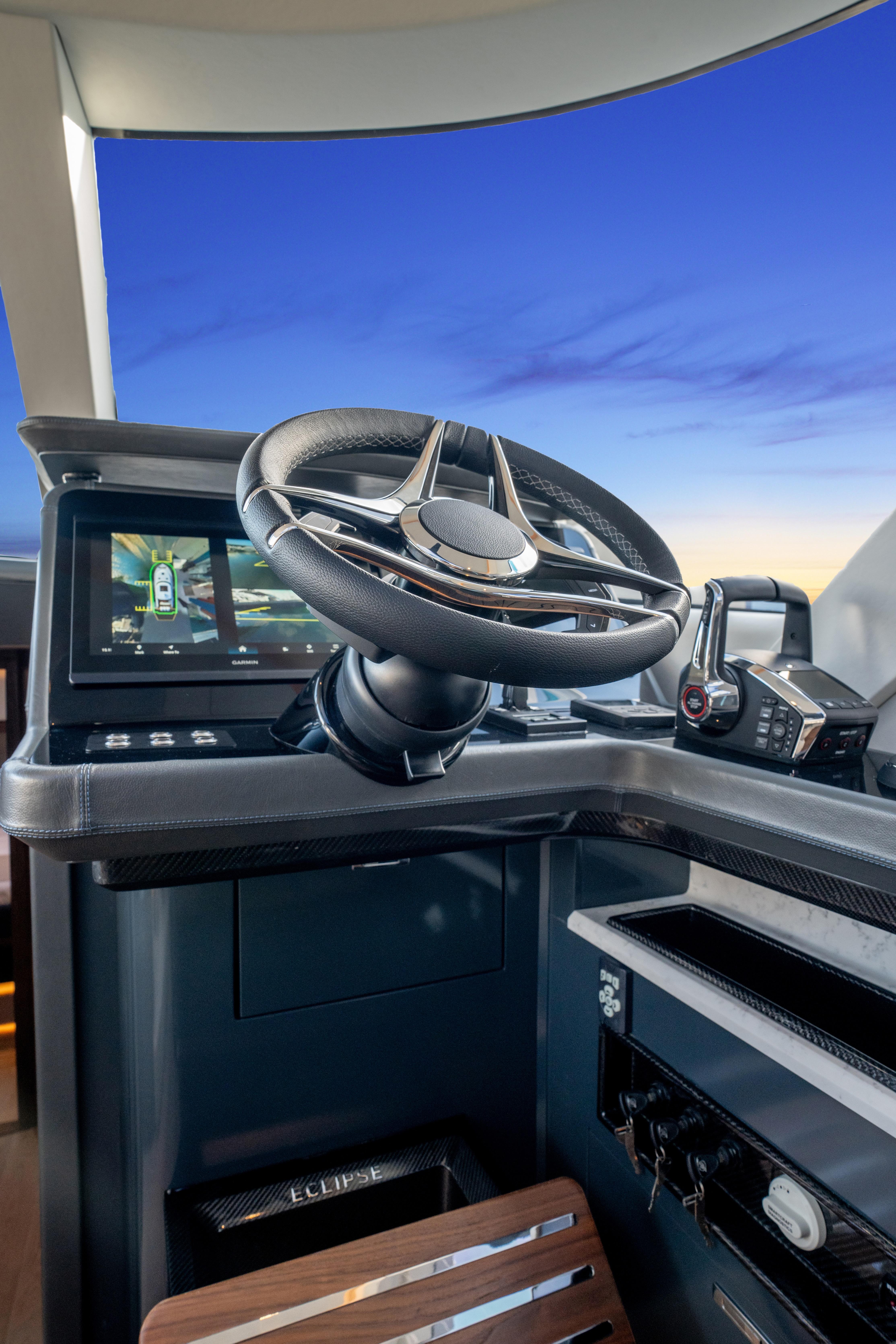 Steering wheel of 2025 ECLIPSE 505 Shadow boat against a sunset sky.