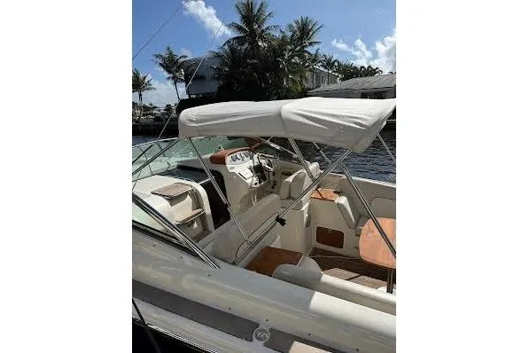 Andiamo Yacht Photos Pics 2006 Chris Craft Corsair Heritage boat with canopy, docked near palm trees.