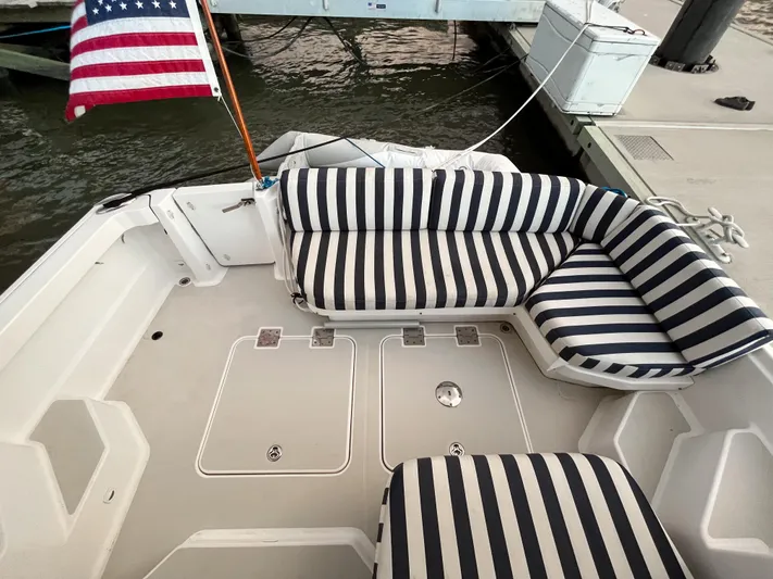  Yacht Photos Pics 2013 Back Cove 34 boat with striped seating and American flag at dock.
