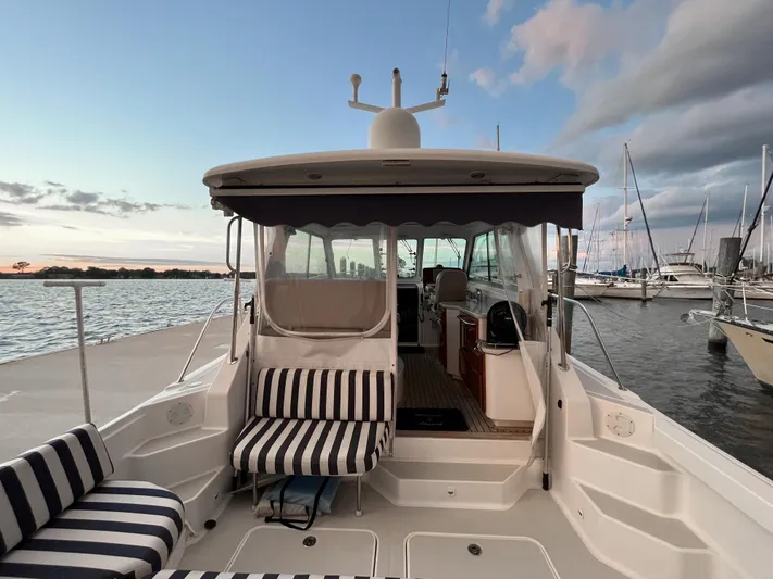  Yacht Photos Pics 2013 Back Cove 34 boat docked, featuring striped seating and a scenic waterfront view.
