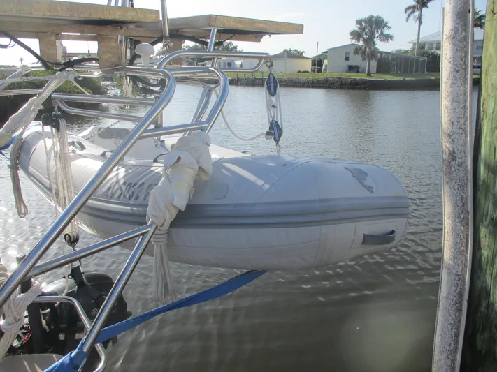  Yacht Photos Pics Inflatable dinghy on Island Packet 380 sailboat, 1999 model, docked by a calm waterway.