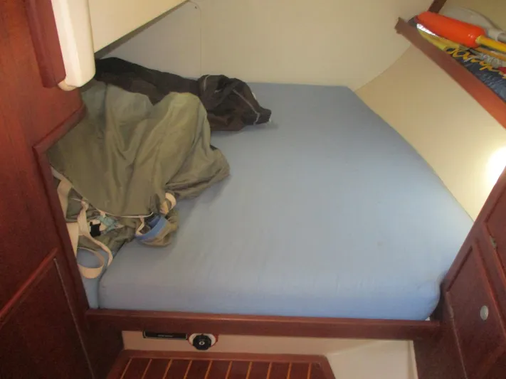  Yacht Photos Pics Cozy cabin bed in 1999 Island Packet 380 sailboat with blue bedding and wooden accents.