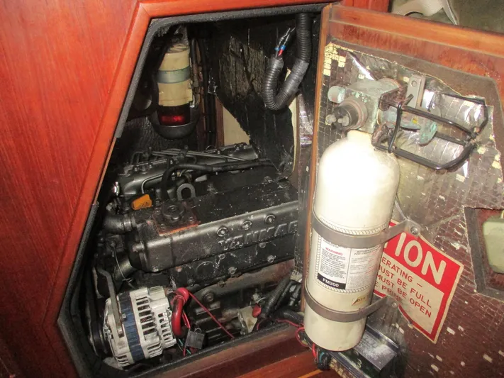  Yacht Photos Pics Engine compartment of a 1999 Island Packet 380 sailboat, featuring a fire extinguisher and caution sign.