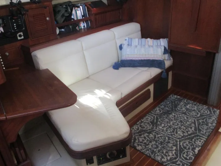  Yacht Photos Pics Interior of 1999 Island Packet 380 yacht with white seating and wooden accents.