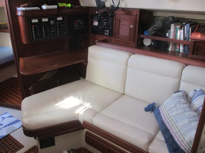  Yacht Photos Pics Interior of 1999 Island Packet 380 sailboat with white seating and navigation equipment.