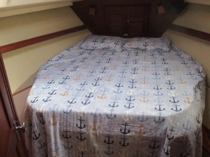  Yacht Photos Pics Cozy cabin interior of 1999 Island Packet 380 sailboat with anchor-patterned bedding.