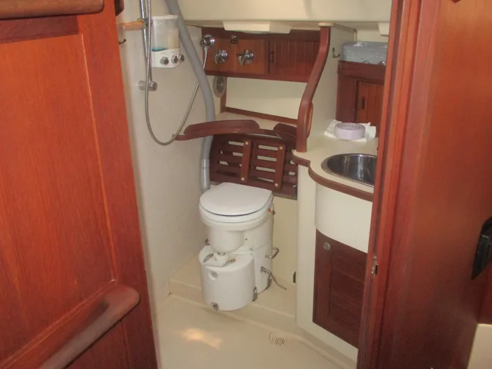  Yacht Photos Pics 1999 Island Packet 380 yacht bathroom with toilet, sink, and wooden cabinetry.