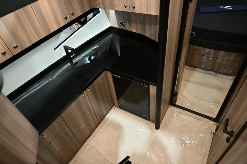 Falcon F-42 2x440 Hp Yanmar Yacht Photos Pics Luxurious kitchen interior of 2025 Falcon Yachts F-42, featuring sleek black countertops and wood cabinetry.