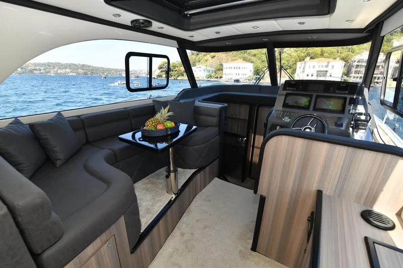 Falcon F-42 2x440 Hp Yanmar Yacht Photos Pics Luxurious interior of 2025 Falcon Yachts F-42 with joystick, featuring elegant seating and scenic views.