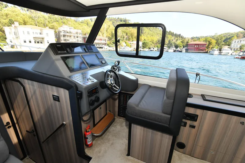 Falcon F-42 2x440 Hp Yanmar Yacht Photos Pics Interior of 2025 Falcon Yachts F-42 with joystick control, overlooking scenic waterfront.