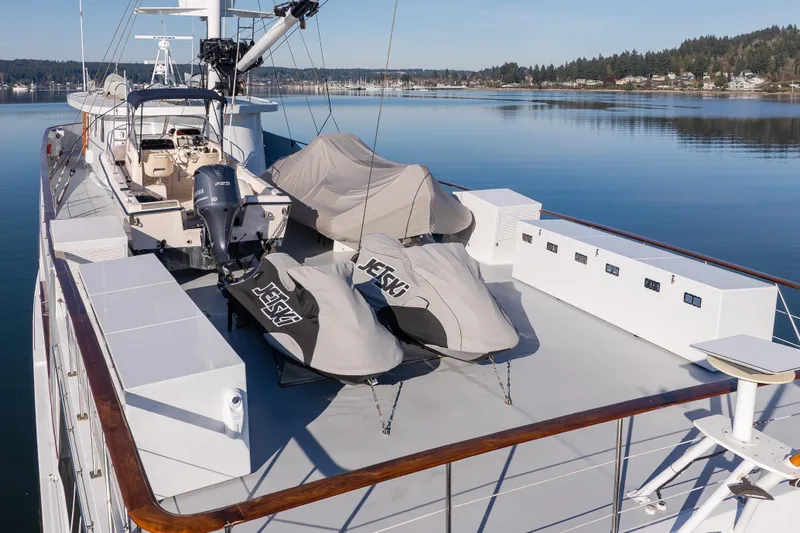  Yacht Photos Pics 1974 Willard 1201 yacht deck with covered jet skis and scenic waterfront view.