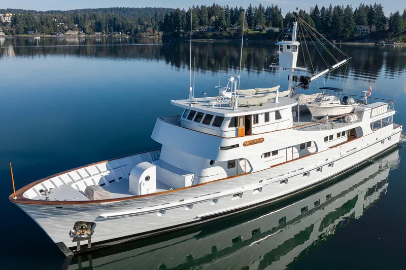  Yacht Photos Pics Vintage 1974 Willard 1201 yacht on serene lake with forested shoreline.