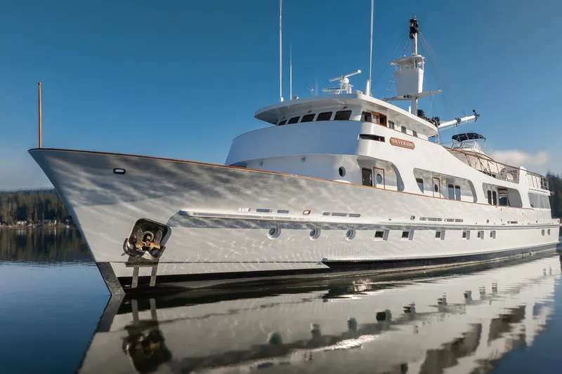  Yacht Photos Pics Luxurious 1974 Willard 1201 yacht reflecting on calm water under clear blue sky.