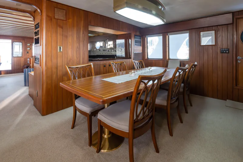  Yacht Photos Pics Elegant dining area on 1974 Willard 1201 yacht with wooden interior and large windows.