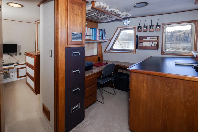  Yacht Photos Pics 1974 Willard 1201 interior with wooden desk, filing cabinet, and scenic window view.