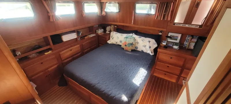 Midnight Yacht Photos Pics Cozy bedroom in 2001 Sabreline 43 Flybridge Motoryacht with wood paneling and nautical decor.