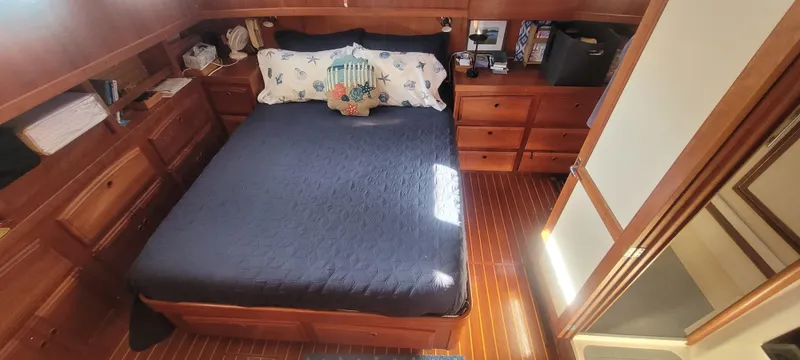 Midnight Yacht Photos Pics Cozy bedroom in 2001 Sabreline 43 Flybridge Motoryacht with wooden cabinetry and nautical decor.