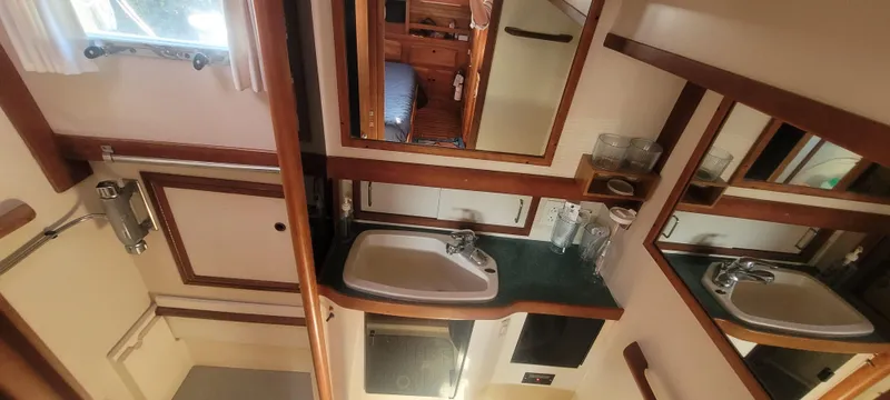 Midnight Yacht Photos Pics Interior of 2001 Sabreline 43 Flybridge Motoryacht bathroom with sink, mirror, and shower.