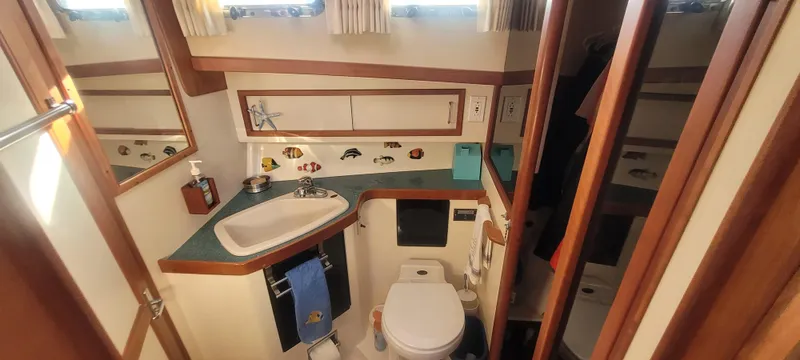 Midnight Yacht Photos Pics 2001 Sabreline 43 Flybridge Motoryacht bathroom with sink, toilet, and nautical decor.