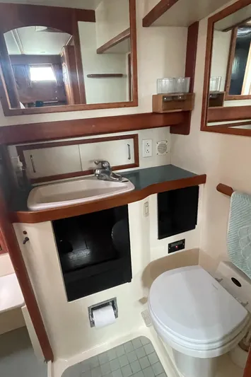 Midnight Yacht Photos Pics Bathroom interior of 2001 Sabreline 43 Flybridge Motoryacht, featuring sink, toilet, and mirror.
