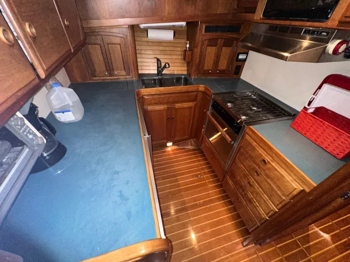 Midnight Yacht Photos Pics Galley kitchen in 2001 Sabreline 43 Flybridge Motoryacht, featuring wood cabinetry and modern appliances.