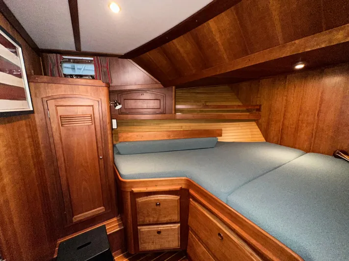 Midnight Yacht Photos Pics 2001 Sabreline 43 Flybridge Motoryacht cabin with wooden interior and blue bedding.