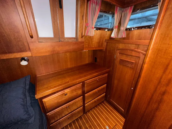 Midnight Yacht Photos Pics Interior of 2001 Sabreline 43 Flybridge Motoryacht, featuring wooden cabinetry and striped curtains.