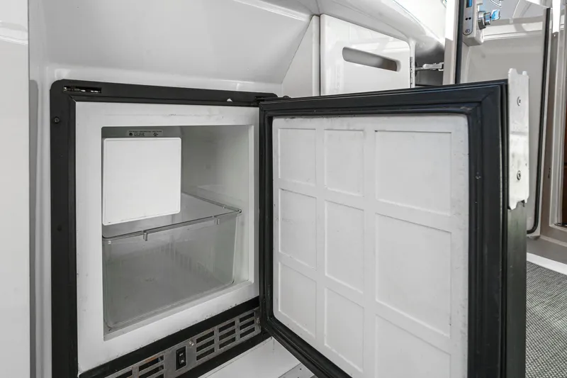 Enough 4 Now! Yacht Photos Pics Open refrigerator on 2005 Sea Ray 500 Sundancer yacht, showcasing interior storage space.