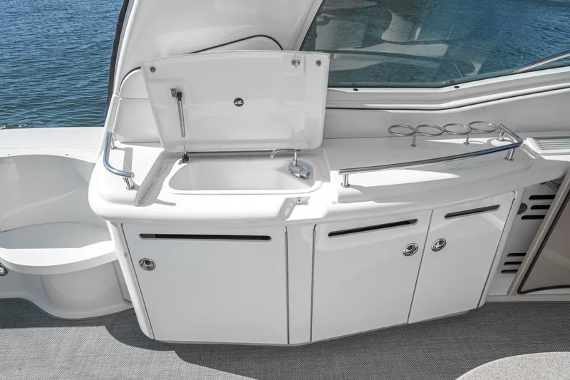 Enough 4 Now! Yacht Photos Pics 2005 Sea Ray 500 Sundancer yacht kitchenette with sink and storage, overlooking water.