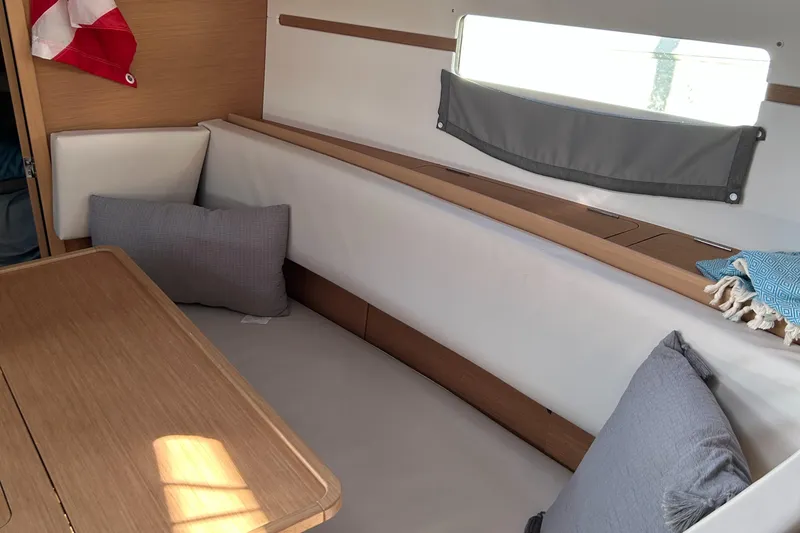  Yacht Photos Pics Interior of 2023 Jeanneau Sun Odyssey 349 sailboat with cozy seating and cushions.