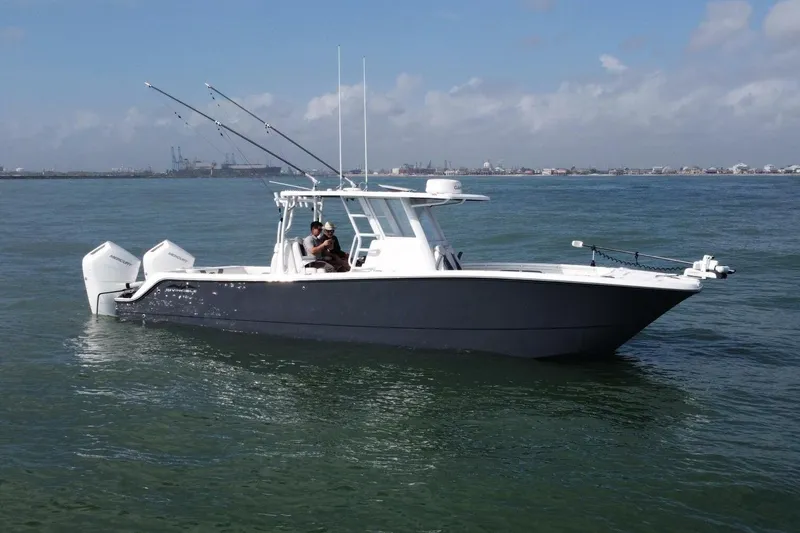 Kuhl Breeze Yacht Photos Pics 2024 Invincible 33 Catamaran on calm water, featuring dual engines and fishing rods.