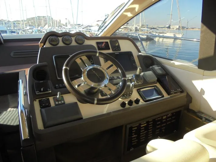  Yacht Photos Pics Cockpit of 2012 Azimut 55S yacht with steering wheel and control panel, docked at marina.